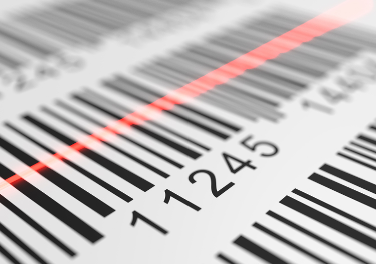 A close-up of barcode labels with a red laser scanner line moving across them. 